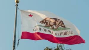 California flag on flagpole flying against a blue sky